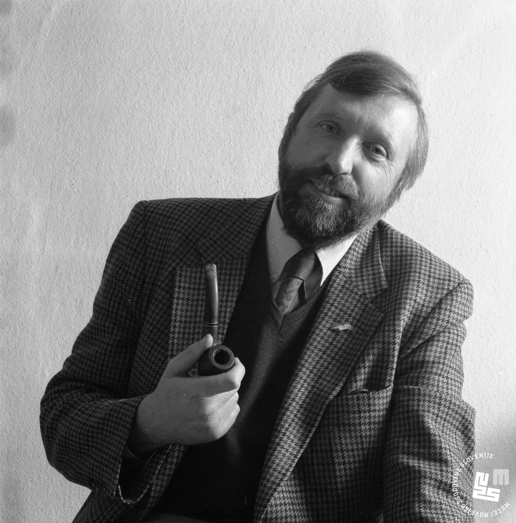 Črno-beli sedeči portret bradatega moškega s pipo
